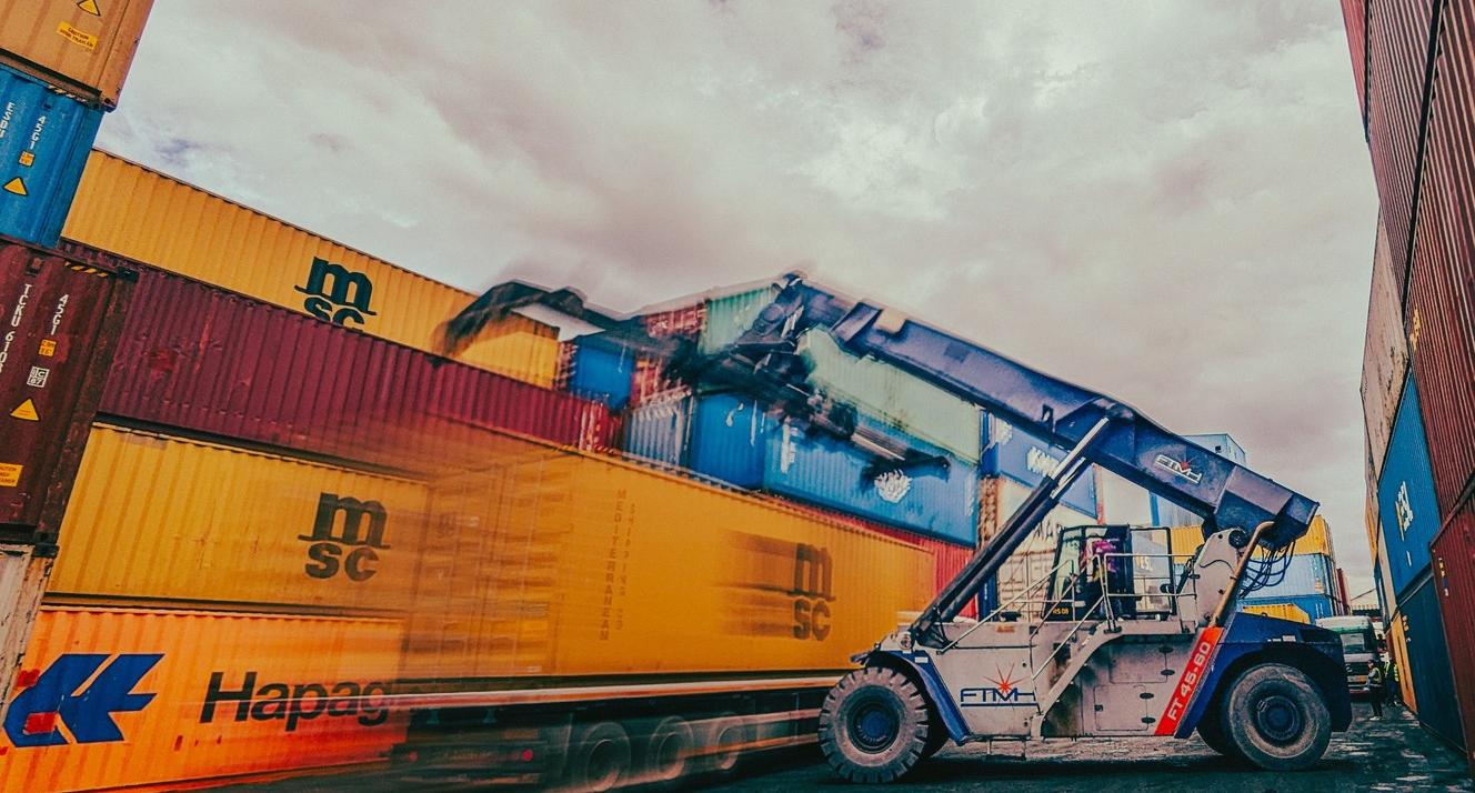 Shipping containers being moved by truck by Alex Levis on Pexels