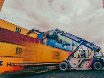 Shipping containers being moved by truck by Alex Levis on Pexels